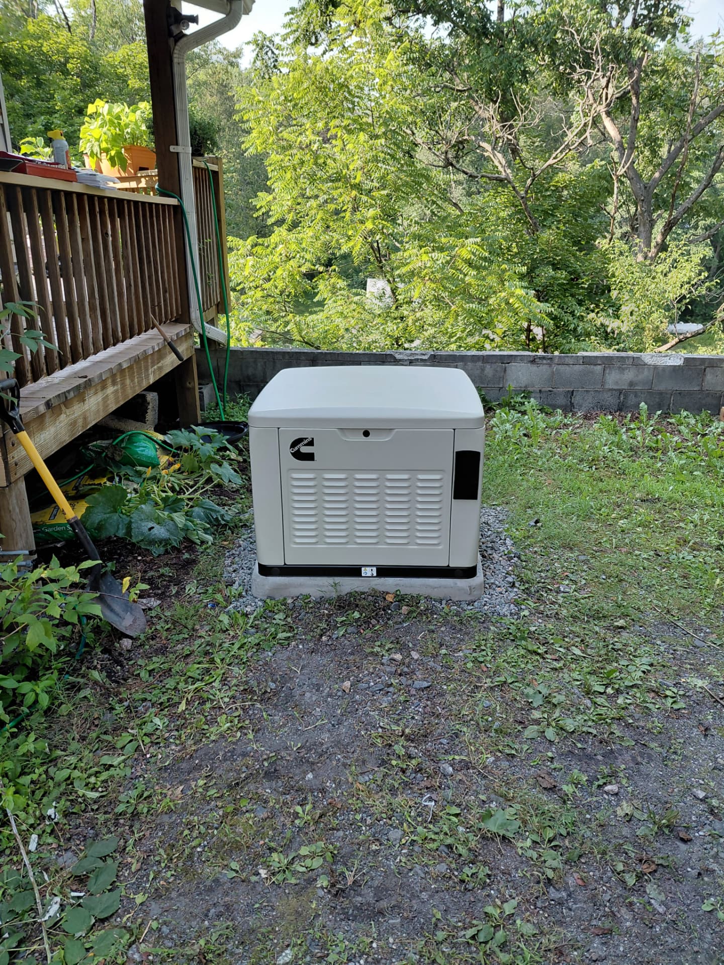 Cummins standby generator set on a concrete pad beside a home, installed by ALM Electric