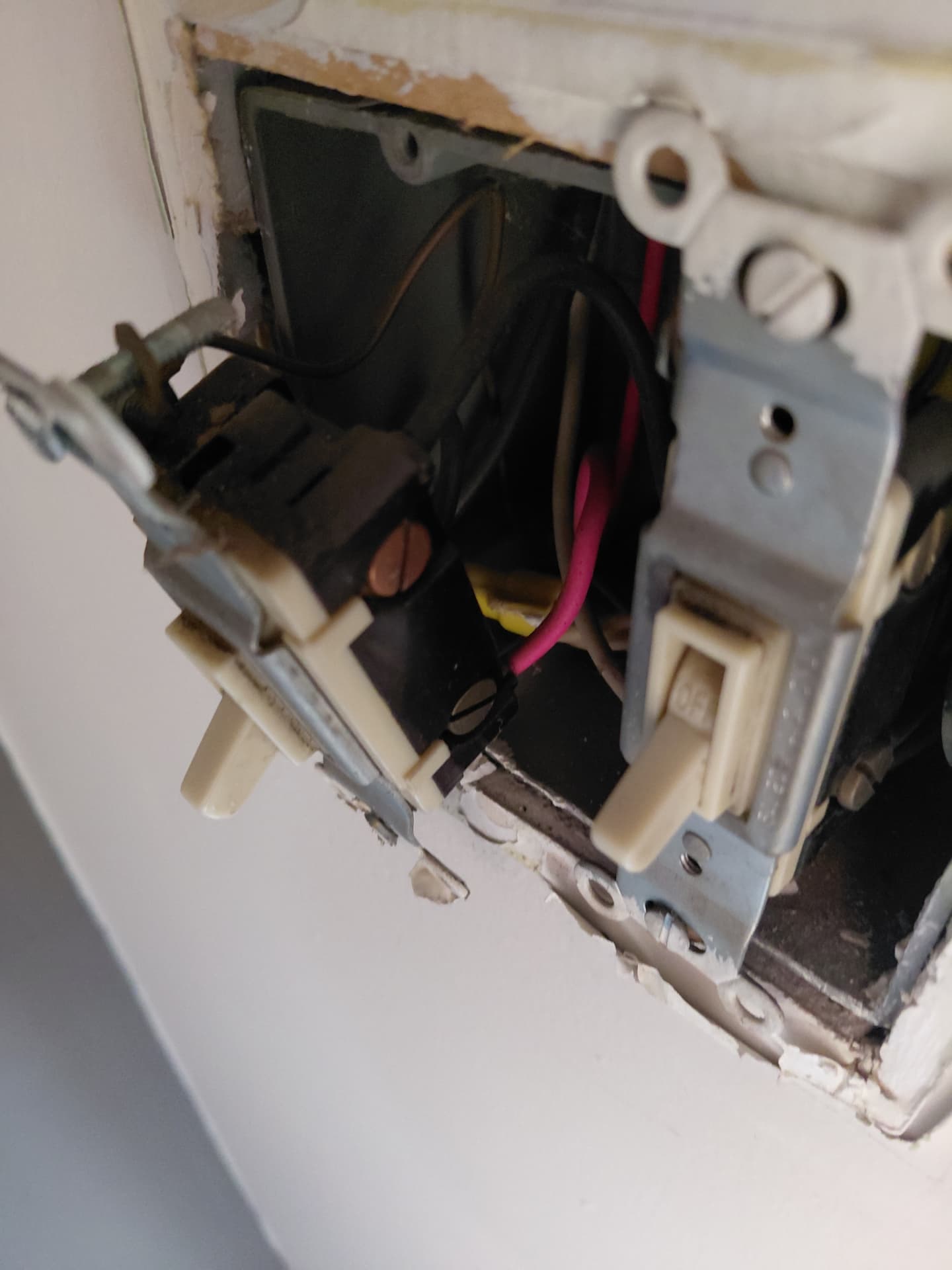 Aging switches and wiring pulled from a wall box during an electrical repair