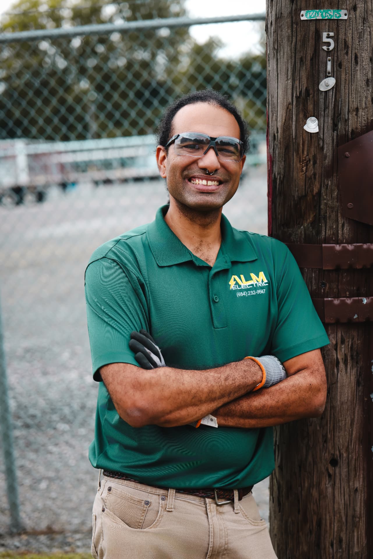 Luis Melecio of ALM Electric leaning against a utility pole
