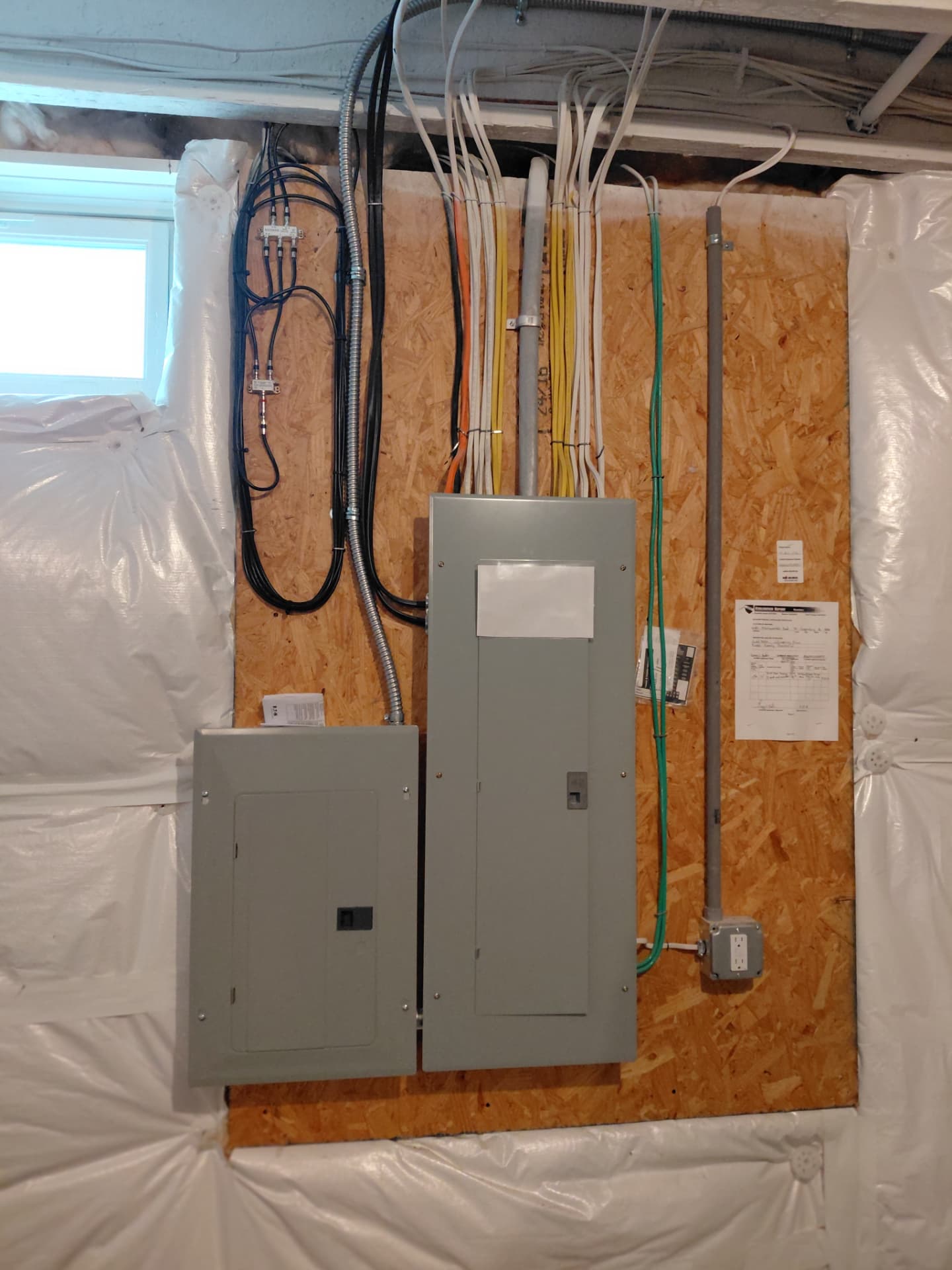 Main electrical panel and subpanel installed with neatly routed circuits in a basement