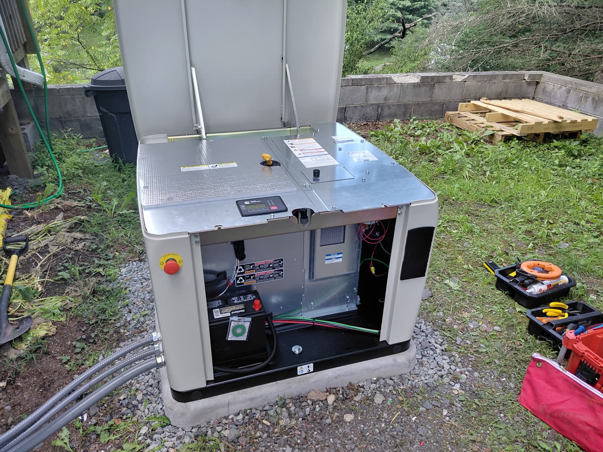 Standby generator opened during commissioning, showing the battery and flexible conduit feed